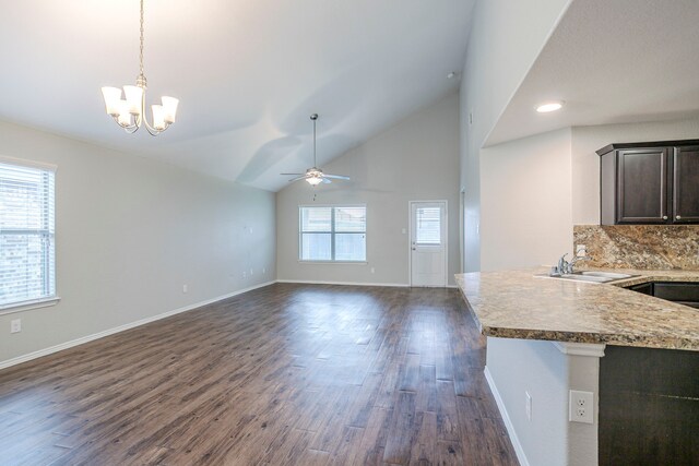 interior space featuring dark brown cabinetry, dark wood-style flooring, hanging light fixtures, a sink, and ceiling fan with notable chandelier