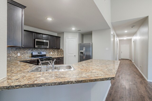 15459 Refugio Verde Way, Houston, TX 77049 - kitchen with a sink, stainless steel appliances, baseboards, decorative backsplash, and dark wood-style floors