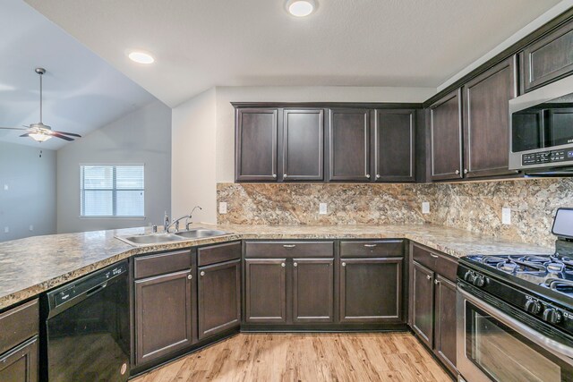 kitchen with dark brown cabinetry, a sink, backsplash, vaulted ceiling, and stainless steel appliances