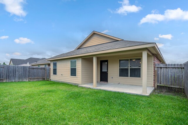back of property featuring a yard, a fenced backyard, and a patio area