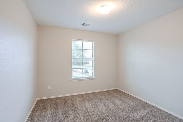 unfurnished room with baseboards, carpet flooring, and visible vents