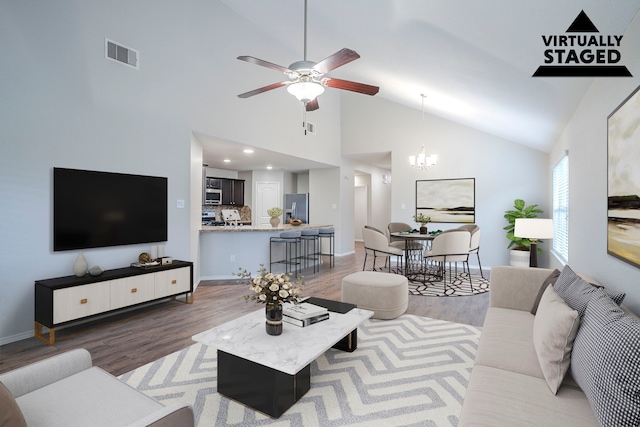 15459 Refugio Verde Way, Houston, TX 77049 - living area featuring ceiling fan with notable chandelier, high vaulted ceiling, light wood-type flooring, visible vents, and baseboards