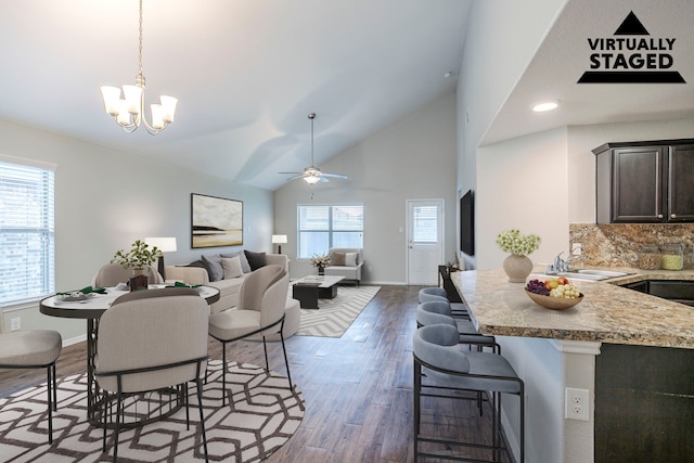 15459 Refugio Verde Way, Houston, TX 77049 - dining area featuring baseboards, wood finished floors, ceiling fan with notable chandelier, and high vaulted ceiling