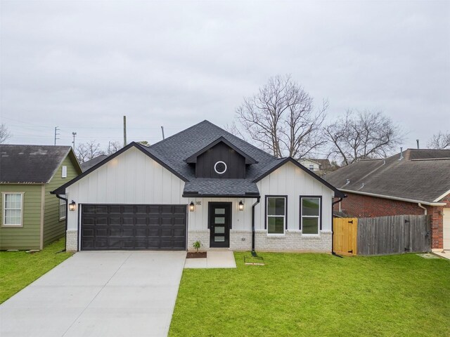 view of front facade with a front lawn, roof with shingles, board and batten siding, an attached garage, and driveway