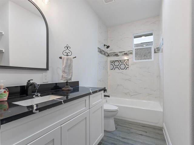 full bath featuring vanity, toilet, tub / shower combination, wood finished floors, and visible vents