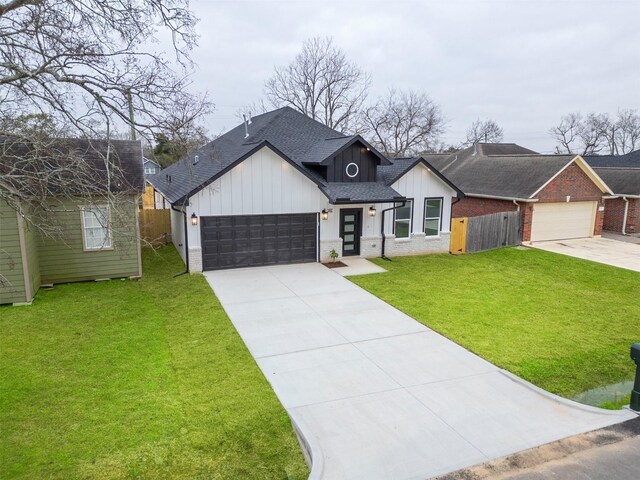 modern inspired farmhouse featuring board and batten siding, fence, a front yard, and concrete driveway