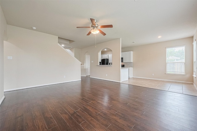 25451 Dappled Filly Dr, Tomball, TX 77375 - unfurnished living room with wood finished floors, baseboards, recessed lighting, arched walkways, and a ceiling fan