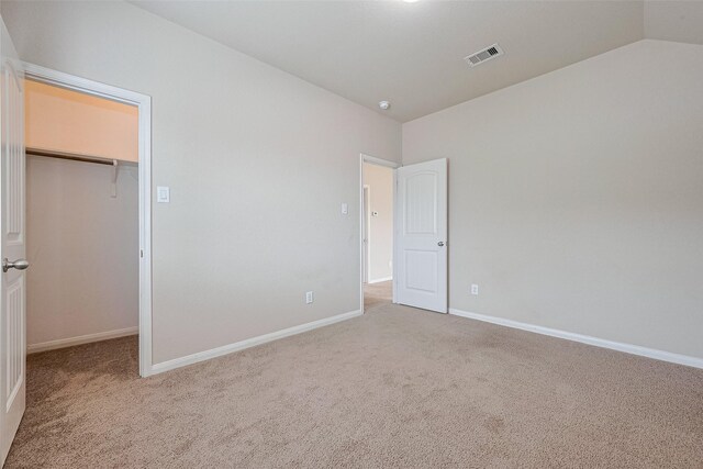 25451 Dappled Filly Dr, Tomball, TX 77375 - unfurnished bedroom with carpet flooring, baseboards, visible vents, and a walk in closet