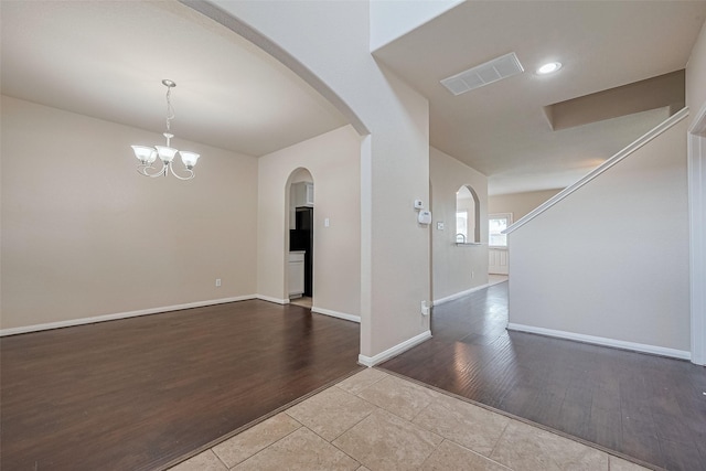 25451 Dappled Filly Dr, Tomball, TX 77375 - spare room with visible vents, arched walkways, wood finished floors, baseboards, and a chandelier