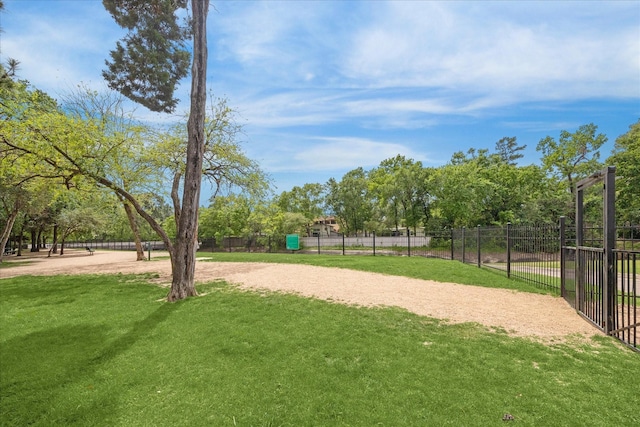 view of home's community with a yard and fence