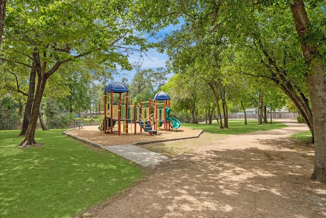 community play area featuring a yard and fence