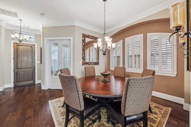 dining area featuring an inviting chandelier, baseboards, dark wood-type flooring, visible vents, and ornamental molding