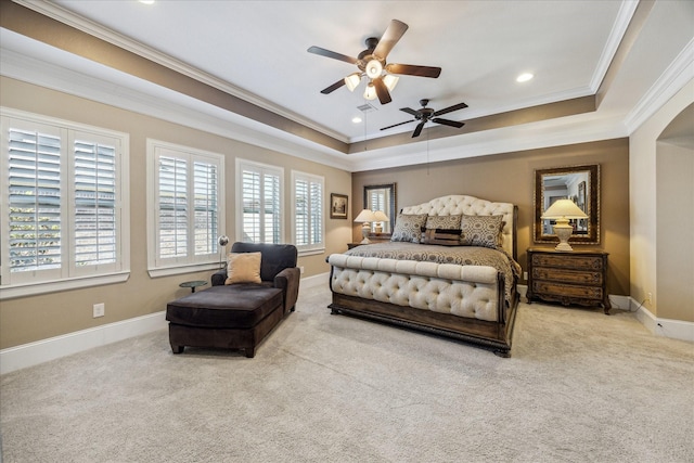 carpeted bedroom featuring crown molding, baseboards, and a raised ceiling
