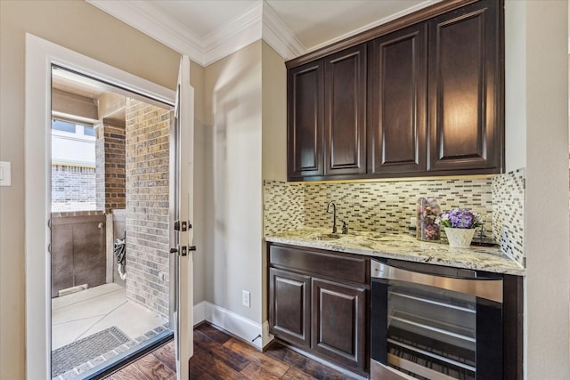 bar with dark wood finished floors, wet bar, decorative backsplash, wine cooler, and ornamental molding