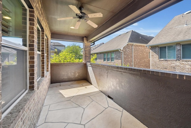 view of patio with ceiling fan and a balcony