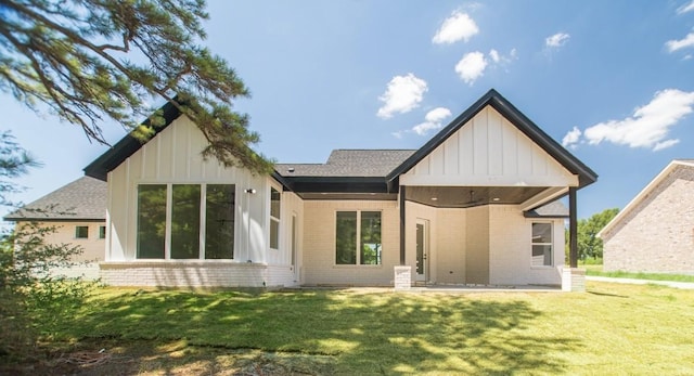 66 Westwood Dr E, Trinity, TX 75862 - back of house with ceiling fan, brick siding, board and batten siding, a patio area, and a lawn