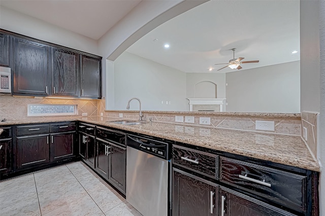 kitchen with ceiling fan, backsplash, appliances with stainless steel finishes, light stone countertops, and a sink
