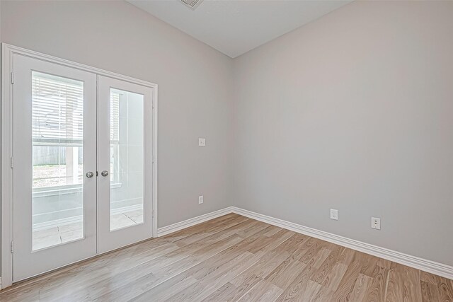 unfurnished room featuring baseboards, french doors, and light wood finished floors