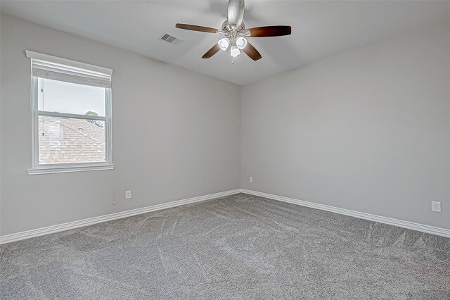 carpeted empty room with a ceiling fan, baseboards, and visible vents