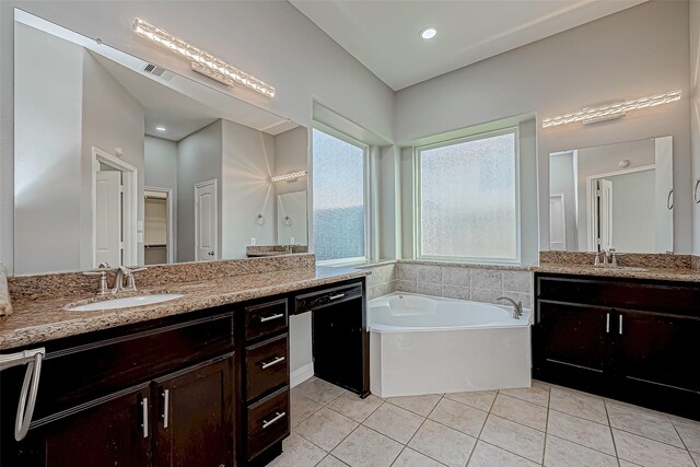 full bath with a sink, tile patterned floors, a garden tub, and two vanities