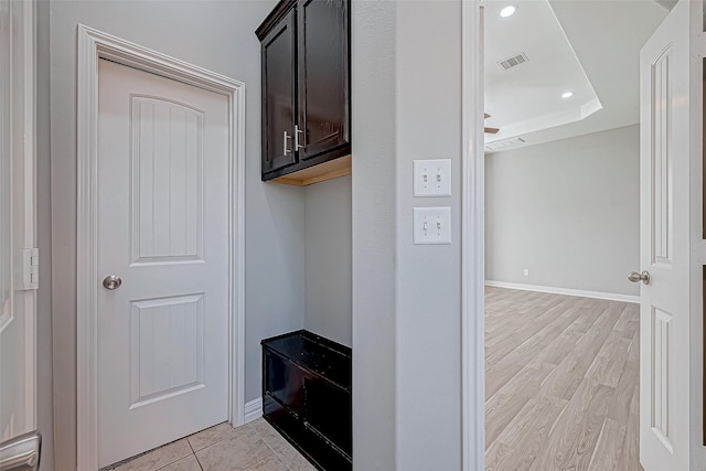 mudroom with visible vents, baseboards, recessed lighting, a tray ceiling, and light wood-style flooring