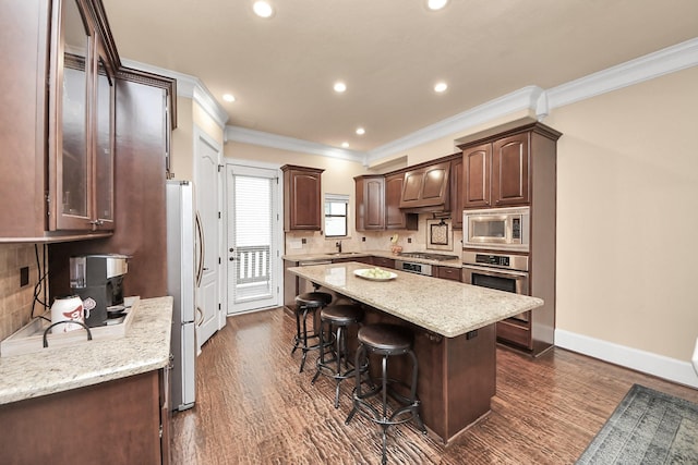 5341 Nolda St Unit E, Houston, TX 77007 - kitchen featuring crown molding, appliances with stainless steel finishes, tasteful backsplash, and a kitchen breakfast bar