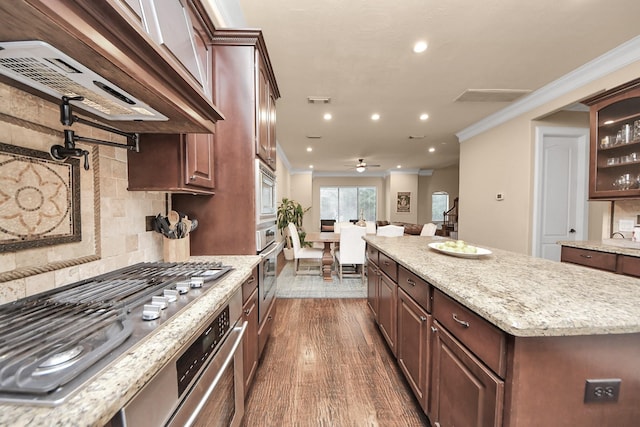 5341 Nolda St Unit E, Houston, TX 77007 - kitchen featuring wall chimney range hood, dark wood-style flooring, ornamental molding, and backsplash