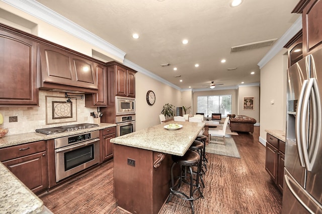 5341 Nolda St Unit E, Houston, TX 77007 - kitchen with a breakfast bar area, open floor plan, appliances with stainless steel finishes, ornamental molding, and recessed lighting