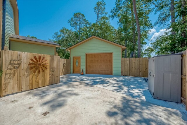 detached garage with fence and concrete driveway