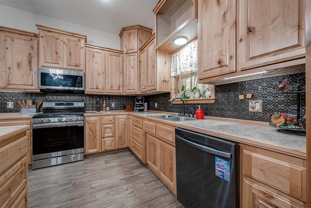 kitchen with light countertops, a sink, light brown cabinets, and stainless steel appliances