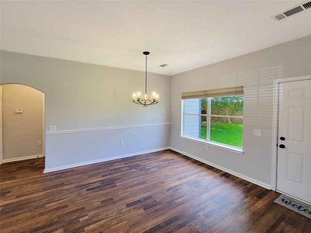 interior space featuring a notable chandelier, arched walkways, baseboards, dark wood-type flooring, and visible vents