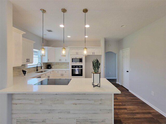 kitchen featuring a sink, white cabinetry, decorative backsplash, visible vents, and black appliances