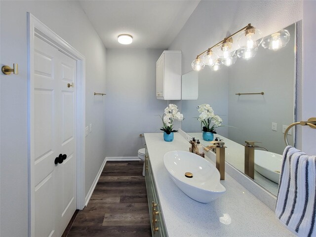 bathroom featuring vanity, baseboards, toilet, and wood finished floors