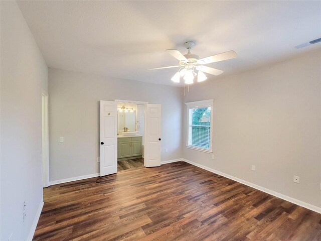 unfurnished bedroom with dark wood-type flooring, baseboards, and visible vents