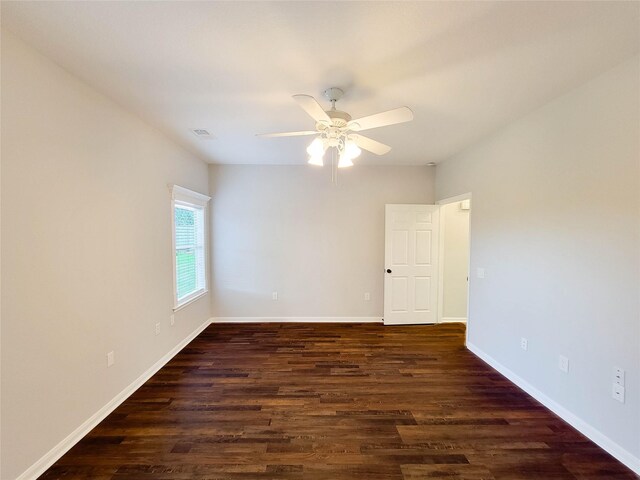 spare room featuring baseboards, dark wood-style flooring, and ceiling fan