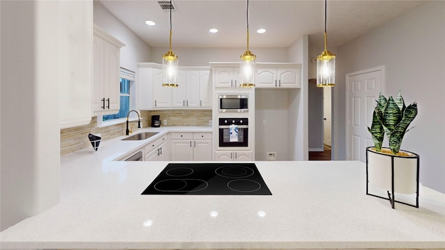 9267 Inlet Cir, Montgomery, TX 77356 - kitchen featuring black electric cooktop, wall oven, a sink, stainless steel microwave, and backsplash