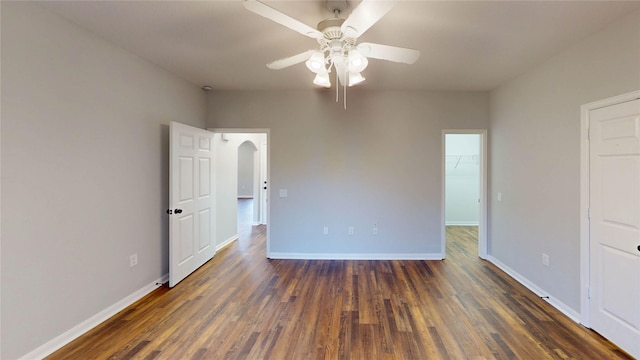 9267 Inlet Cir, Montgomery, TX 77356 - unfurnished bedroom featuring baseboards, wood finished floors, arched walkways, and a walk in closet