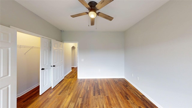 9267 Inlet Cir, Montgomery, TX 77356 - unfurnished bedroom with wood finished floors, baseboards, a closet, arched walkways, and a ceiling fan