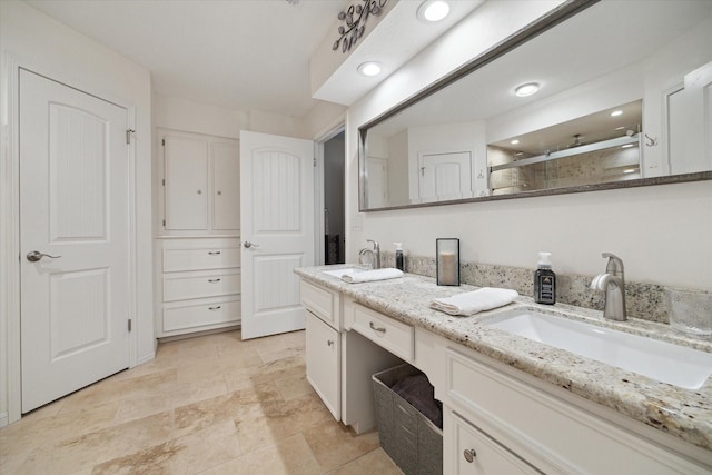 bathroom featuring double vanity, recessed lighting, a sink, and a stall shower