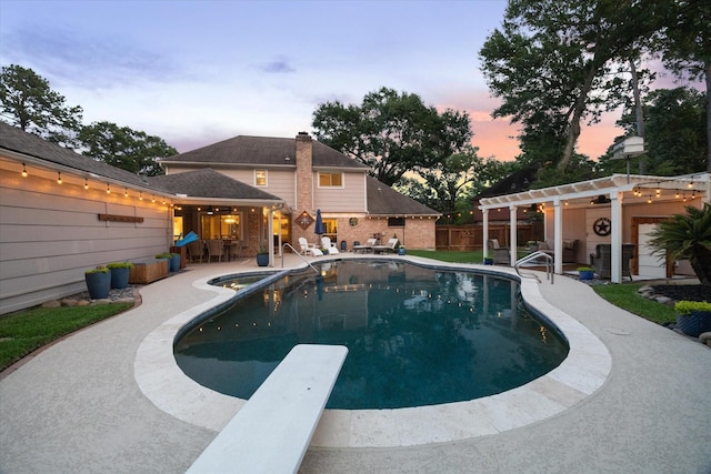 view of pool with a patio, a fenced in pool, fence, and a diving board