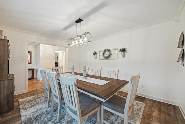 dining space with crown molding, baseboards, and wood finished floors