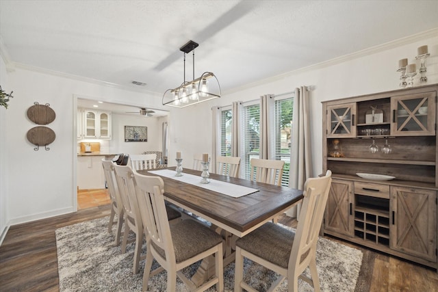 dining space with crown molding and dark wood finished floors
