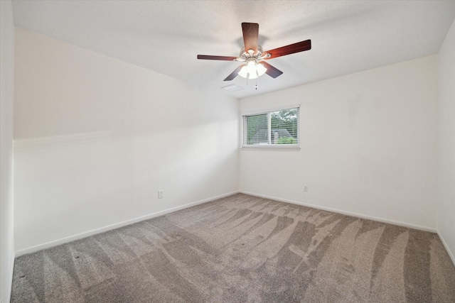 carpeted empty room with baseboards and a ceiling fan