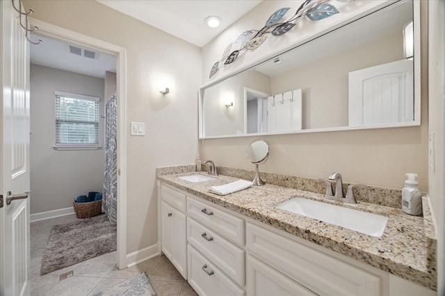 bathroom featuring double vanity, visible vents, a sink, and tile patterned flooring