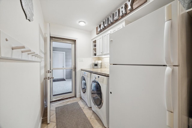 washroom with separate washer and dryer, cabinet space, and light tile patterned flooring