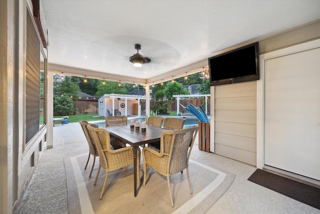 view of patio / terrace with a fenced backyard, a storage unit, and outdoor dining space