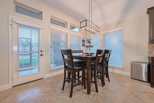 dining area featuring baseboards, a notable chandelier, and light tile patterned floors
