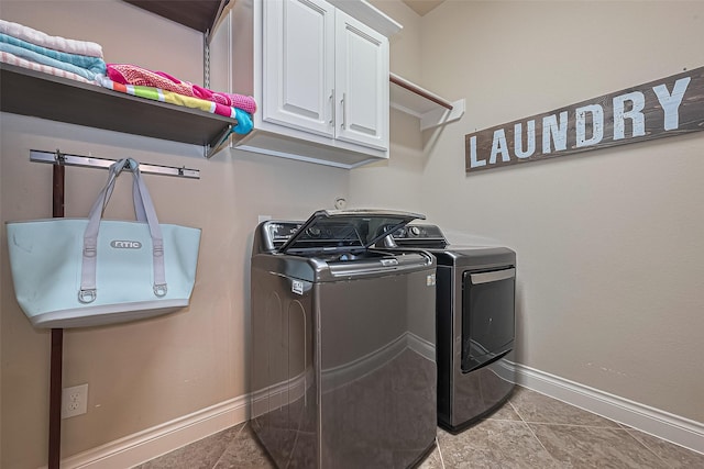 washroom with baseboards, light tile patterned flooring, cabinet space, and washer and dryer