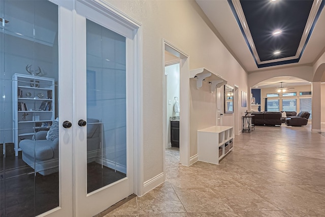 hallway with french doors, arched walkways, and baseboards