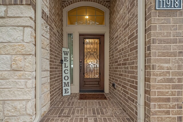doorway to property featuring brick siding